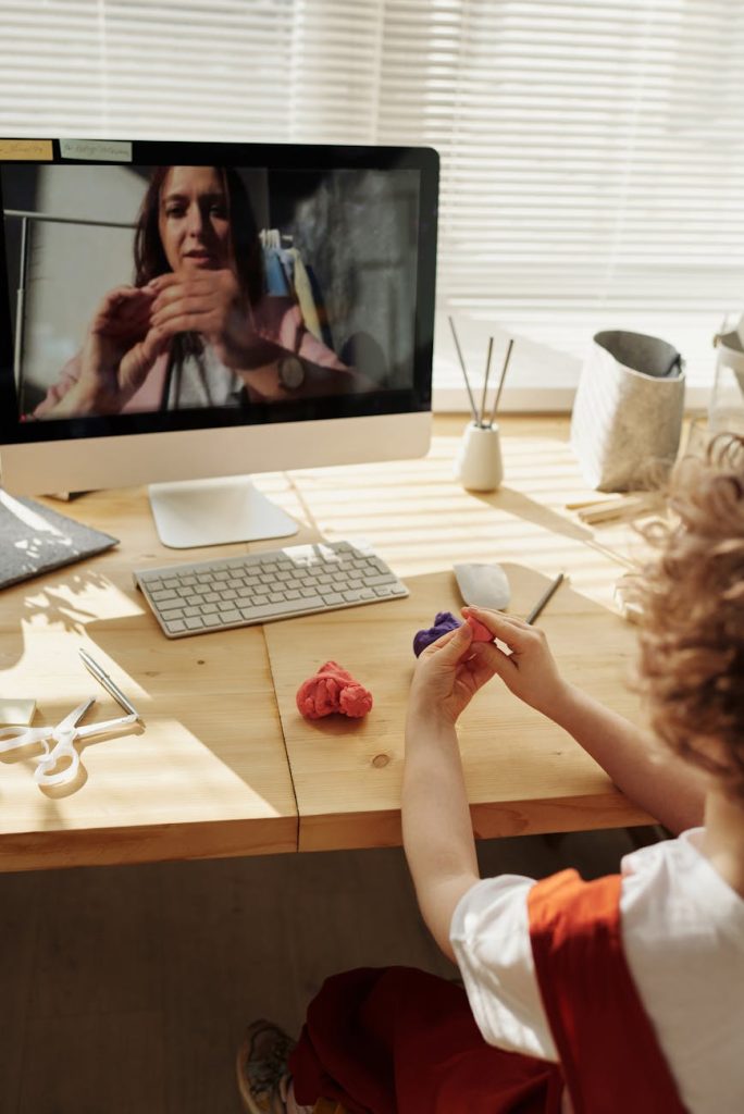 photo of kid playing with clay while looking in the monitor