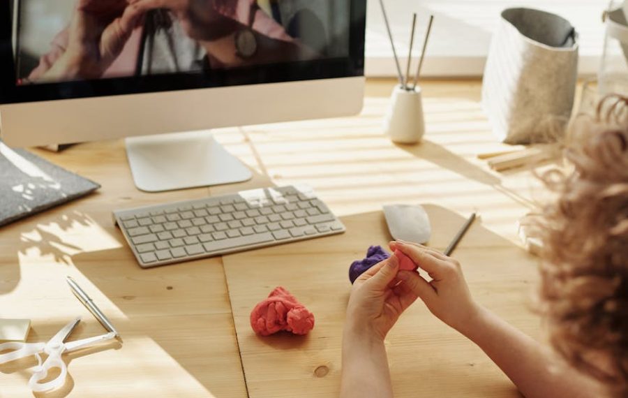 photo of kid playing with clay while looking in the monitor