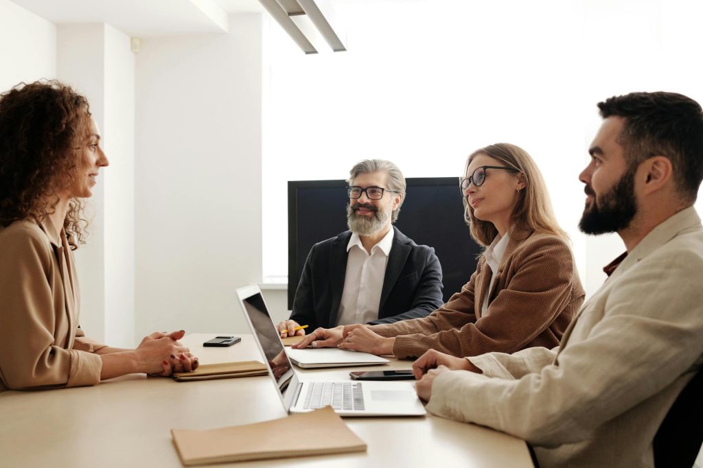 a group of people sitting at the table at a business meeting