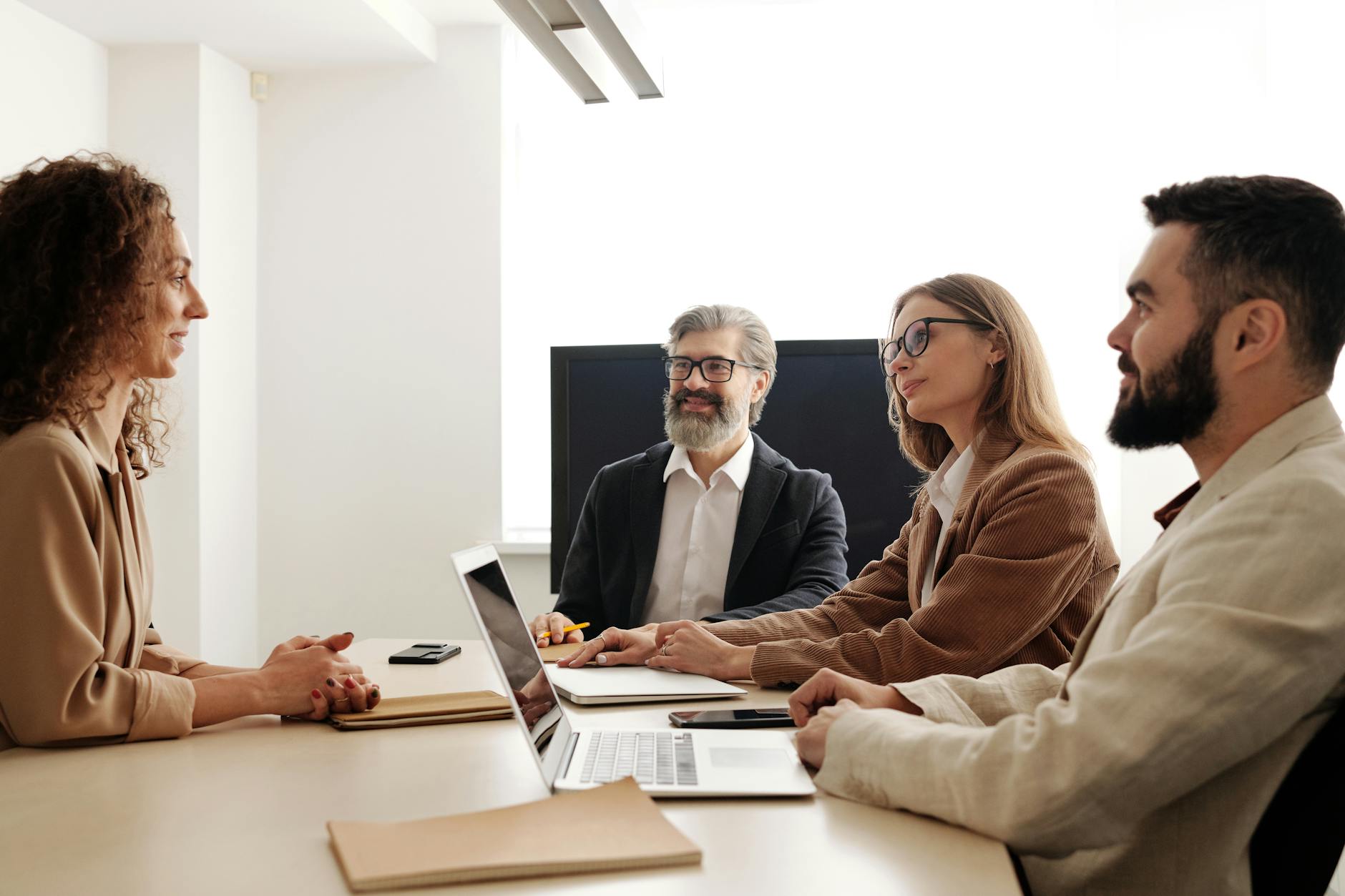 a group of people sitting at the table at a business meeting