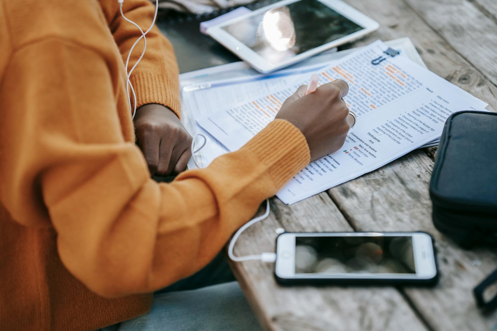 black woman correcting text on paper at table