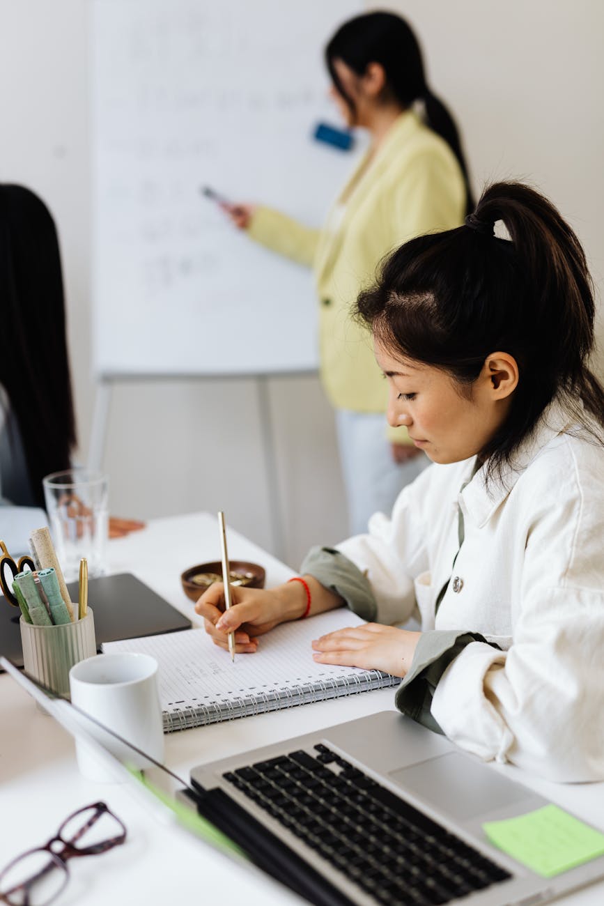 woman taking notes while in a meeting